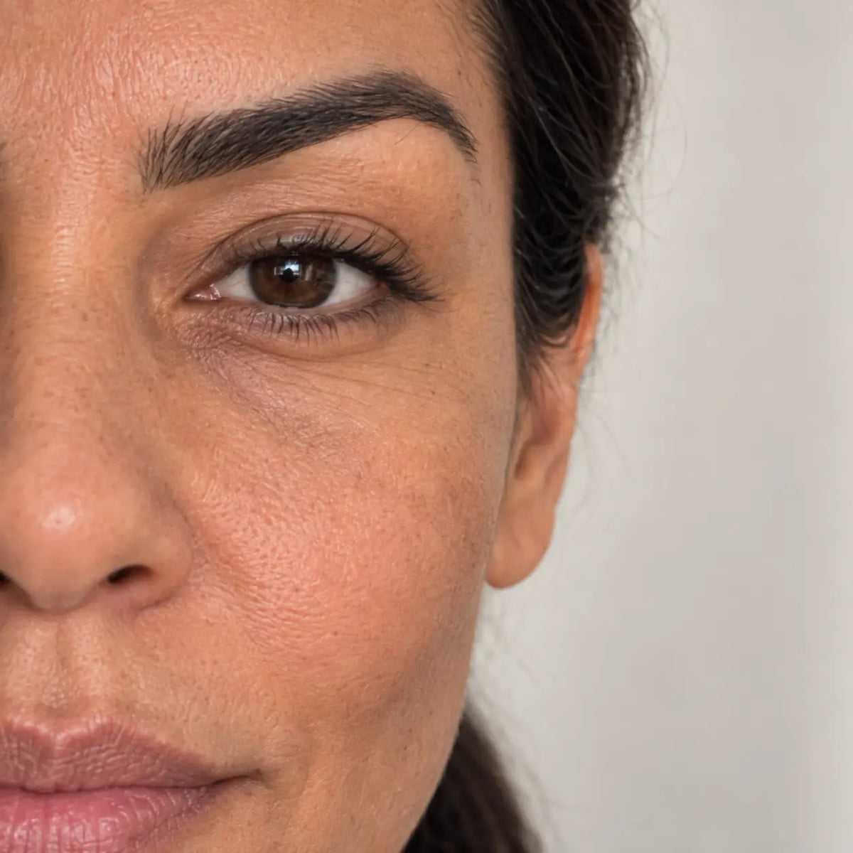 Regard reposé et contour de l'œil lumineux après la Crème Anti-Cernes Glimoir, gros plan en demi-visage