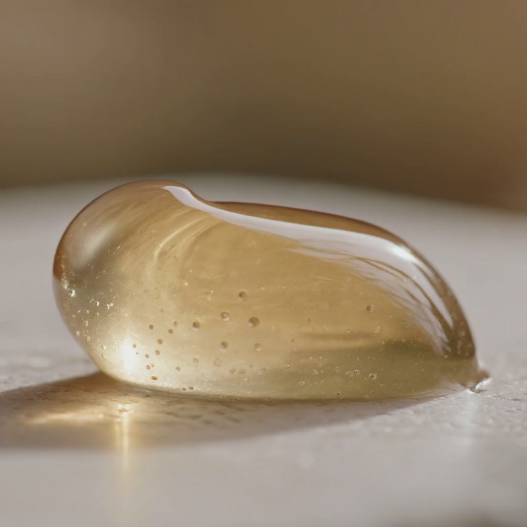 Texture du Gel Booster Caféine Glimoir homme, gel translucide doré qui rebondit sous la pression du doigt