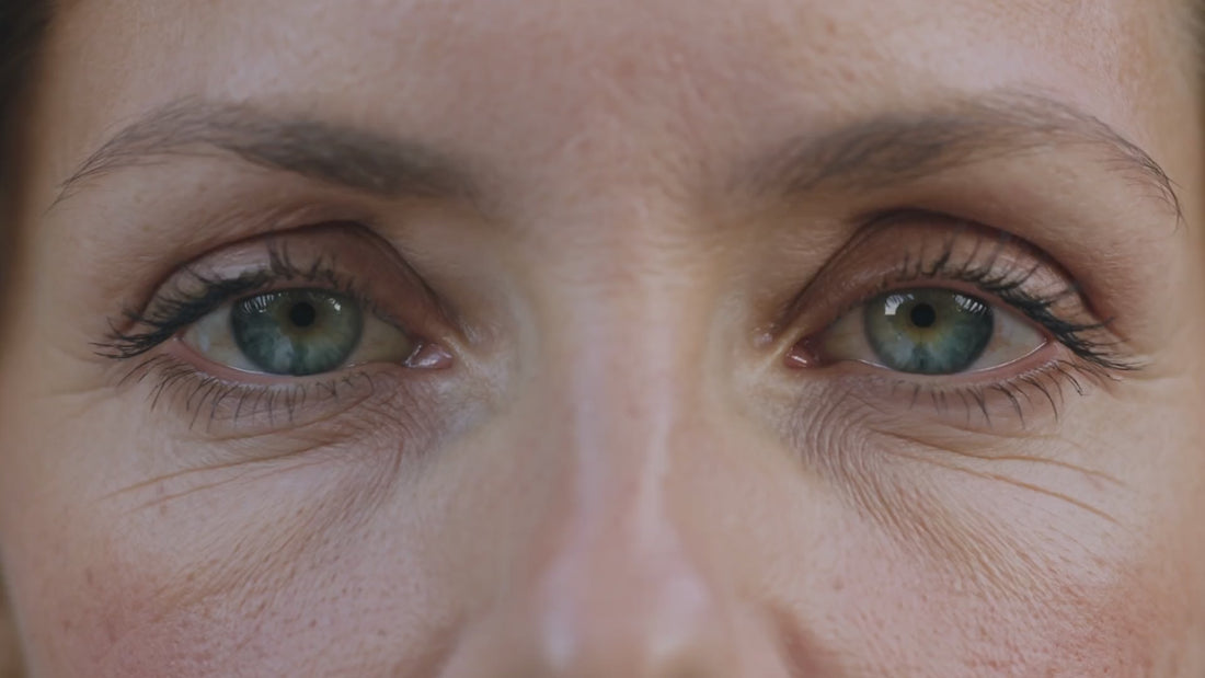 Regard en gros plan qui se ferme puis se rouvre doucement, peau lisse et détendue — crème contour des yeux lissante Glimoir