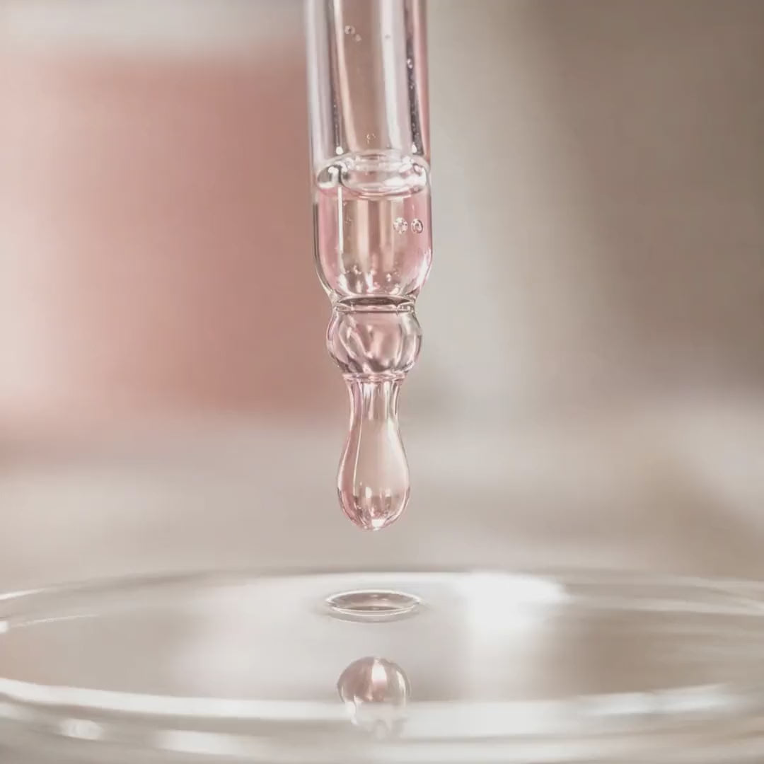 Texture du Sérum Exosomes Glimoir, goutte de sérum rosé qui tombe et ondule à la surface, actifs exosomes et niacinamide